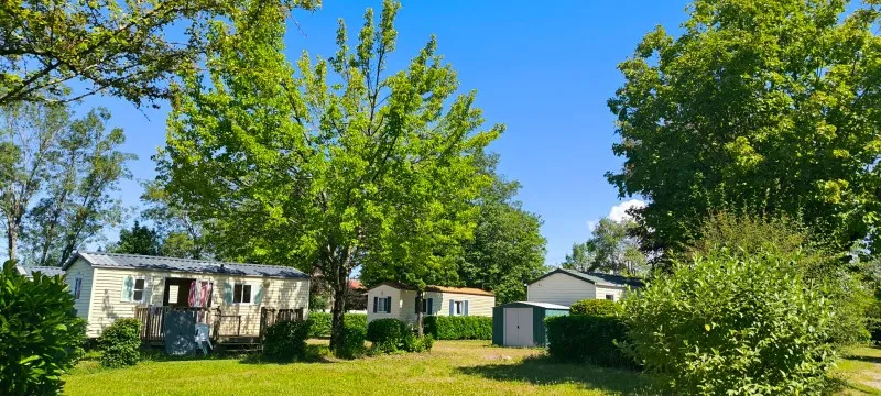 Vue du Camping Del Padel — mobil-homes entourés d'arbres sous un ciel bleu